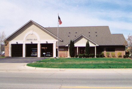 Representative photograph of a brick municipal fire station with apparatus bay doors